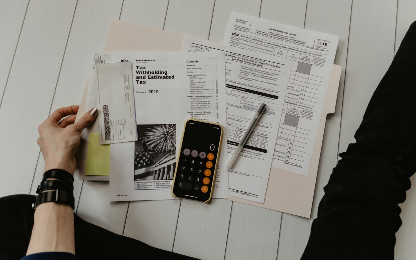 Formulários de imposto, calculadora e caneta sobre a mesa