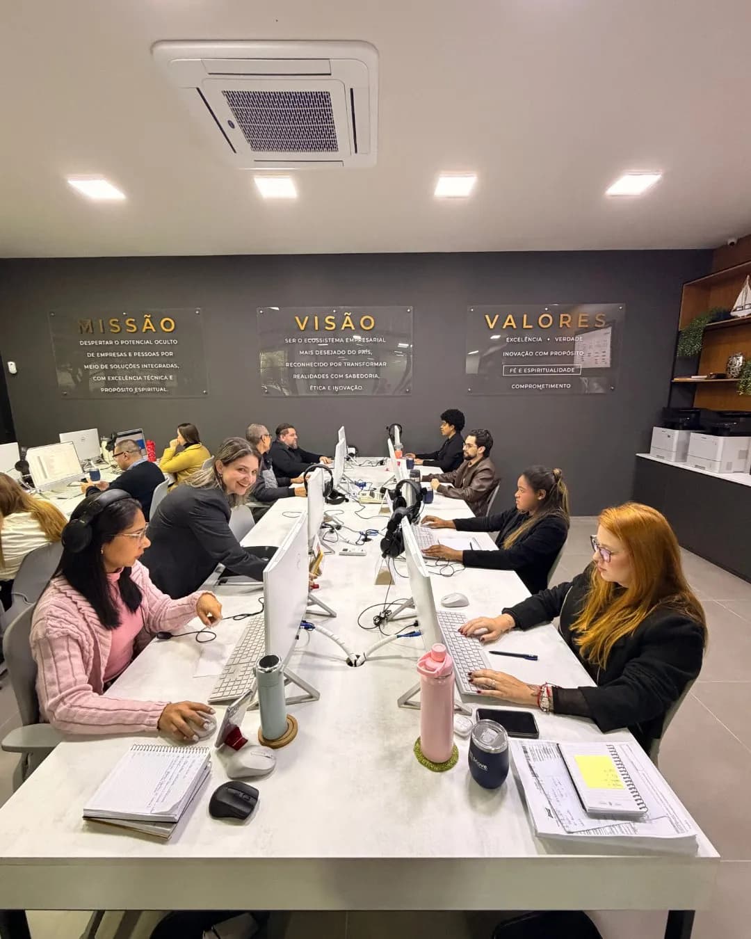 Equipe reunida em volta da mesa, cada um com seu notebook